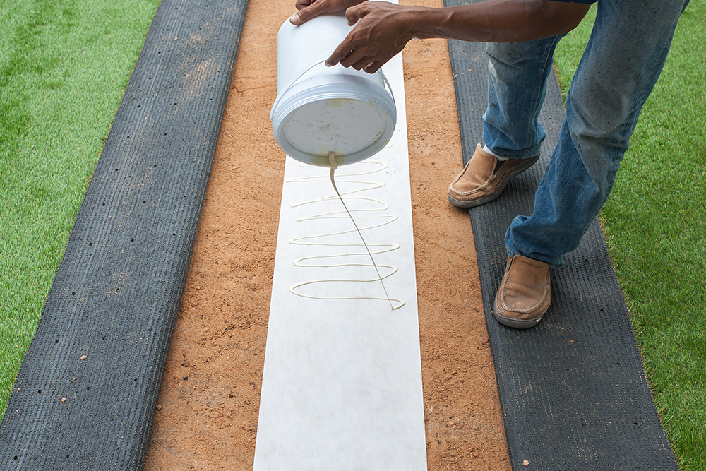 Applying synthetic grass adhesive
